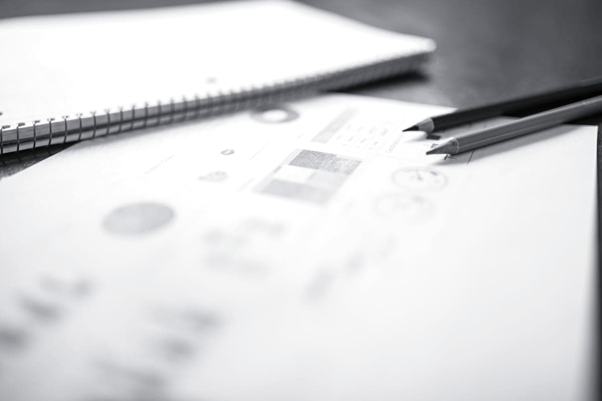 A notebook and pencil on a plain desk, photographed in soft light